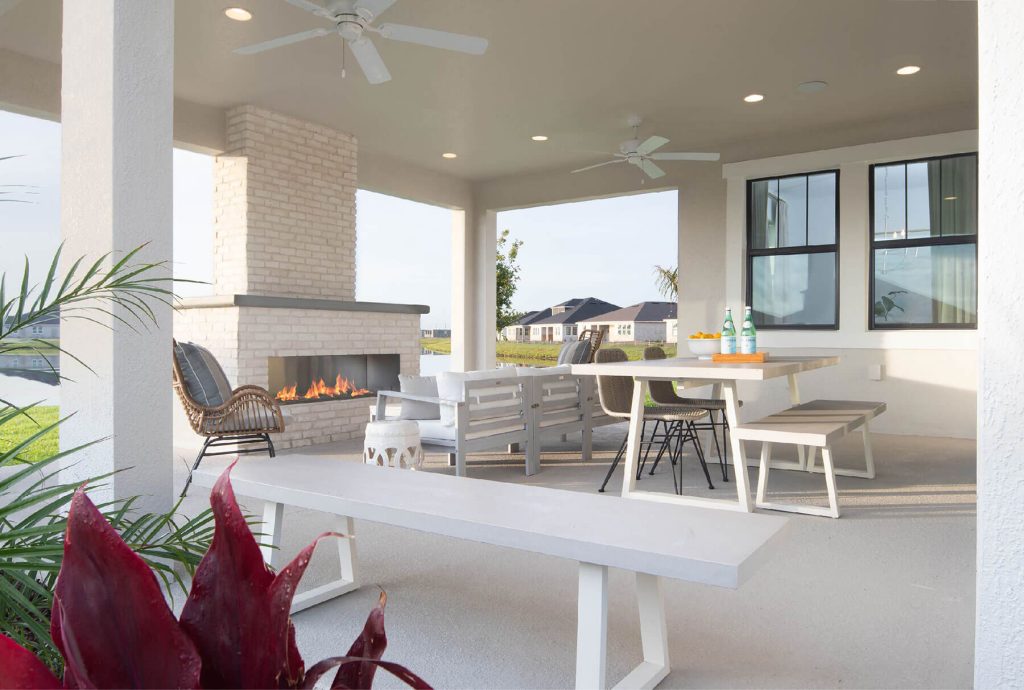 Back patio with a grand fireplace, benches and table