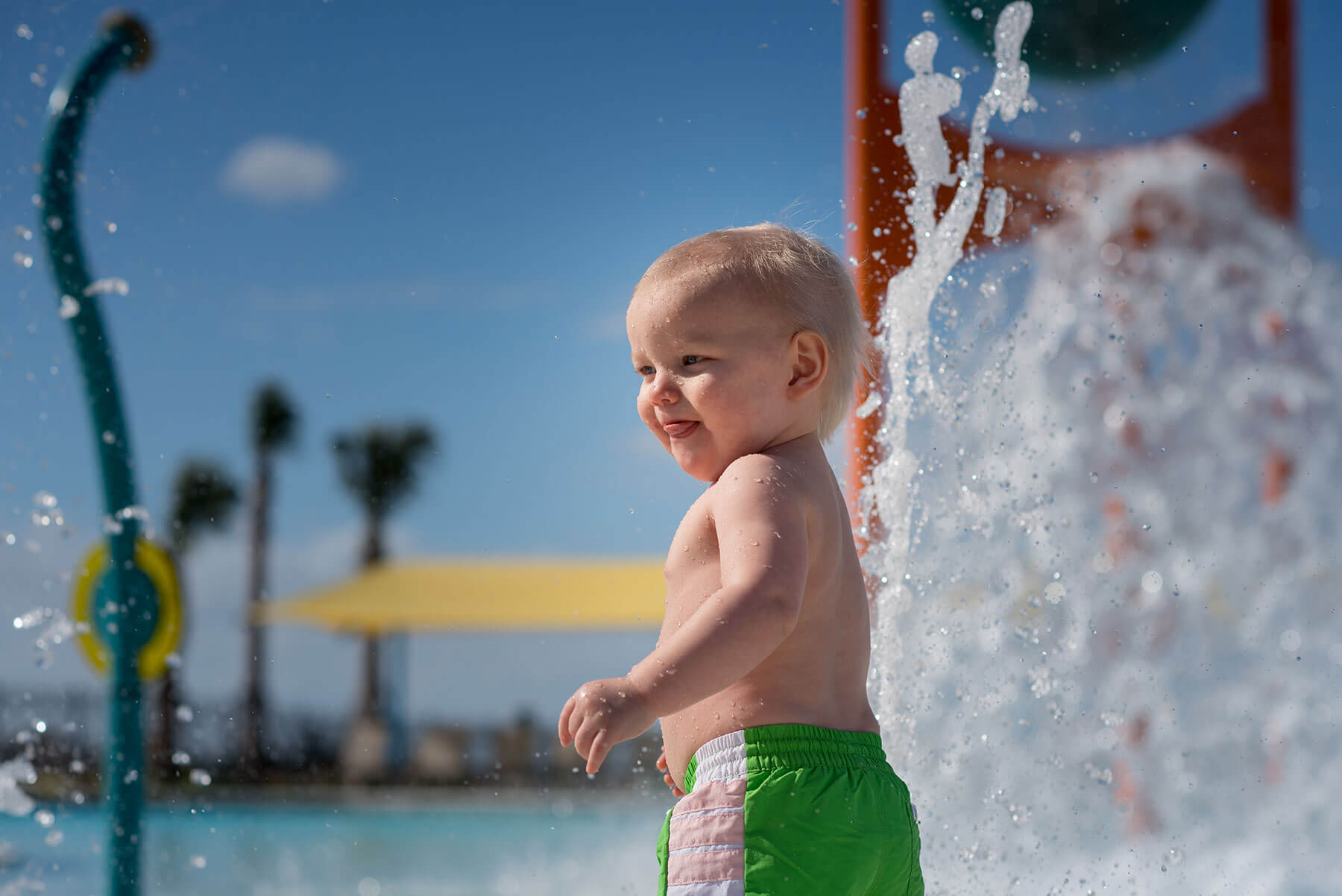 An infant in the splash zone of The Addison Village Club