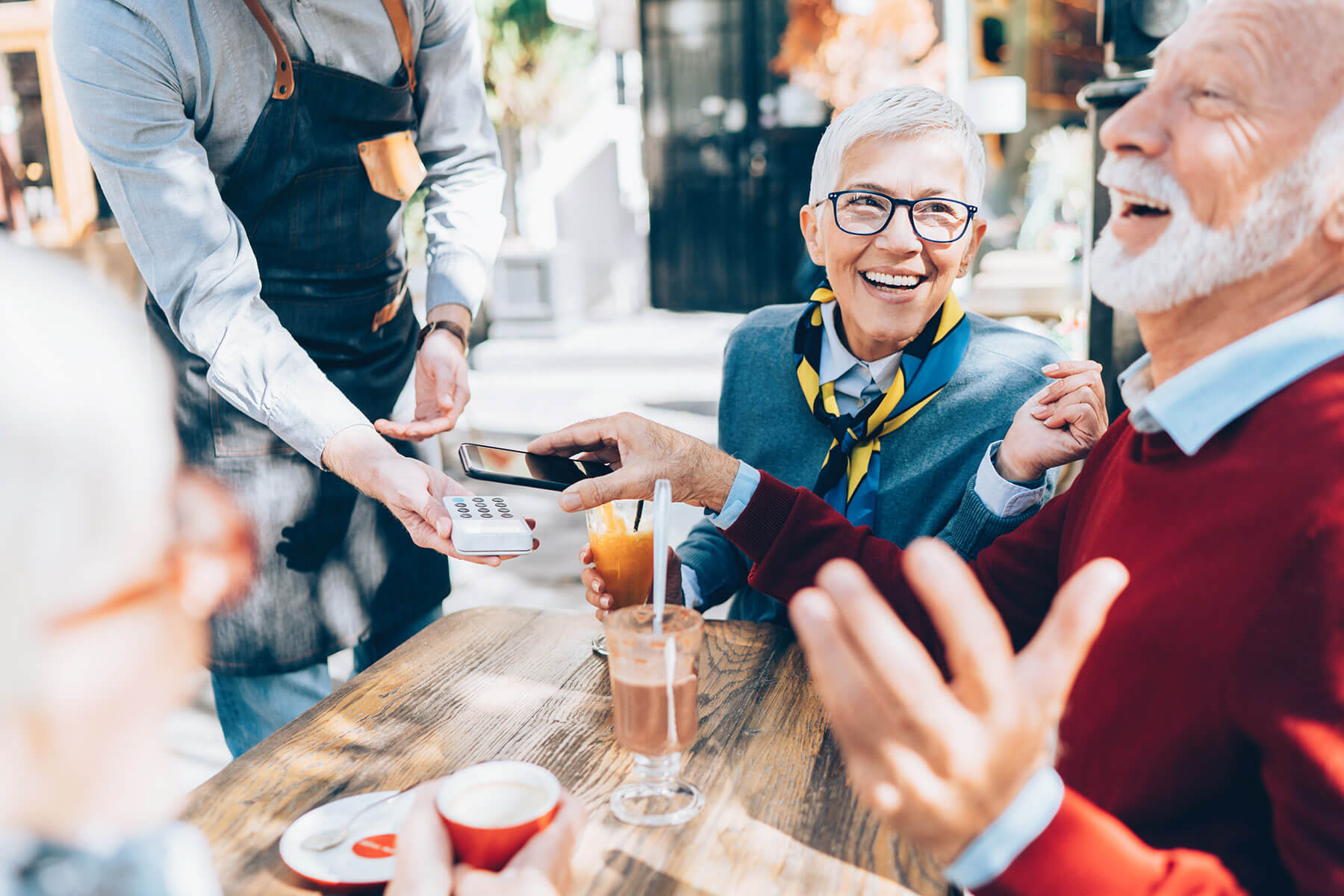 A group of seniors having coffee laughing